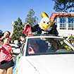 Swoop standing up in the sunroof of a car during the Homecoming Parade